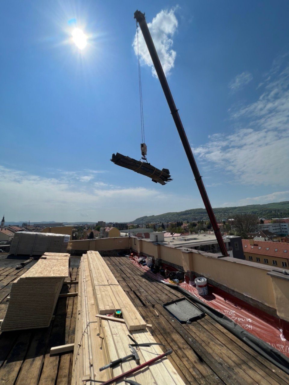 Práce na plochej streche, materiál dvíhaný žeriavom